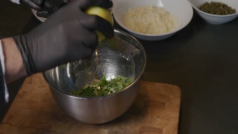 Se-Ve-A-Un-Chef-Rallando-Hábilmente-Un-Limón-Sobre-Un-Tazón,-Mientras-La-Cámara-Gira-Lentamente-Hacia-La-Derecha