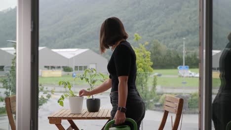 medium shot, young thai woman checking tomato plants on her urban garden