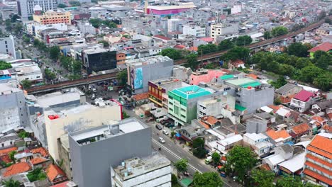 Vista-Aérea-Del-Sistema-De-Metro-De-Tren-Elevado-Sobre-La-Carretera-En-Yakarta,-Indonesia