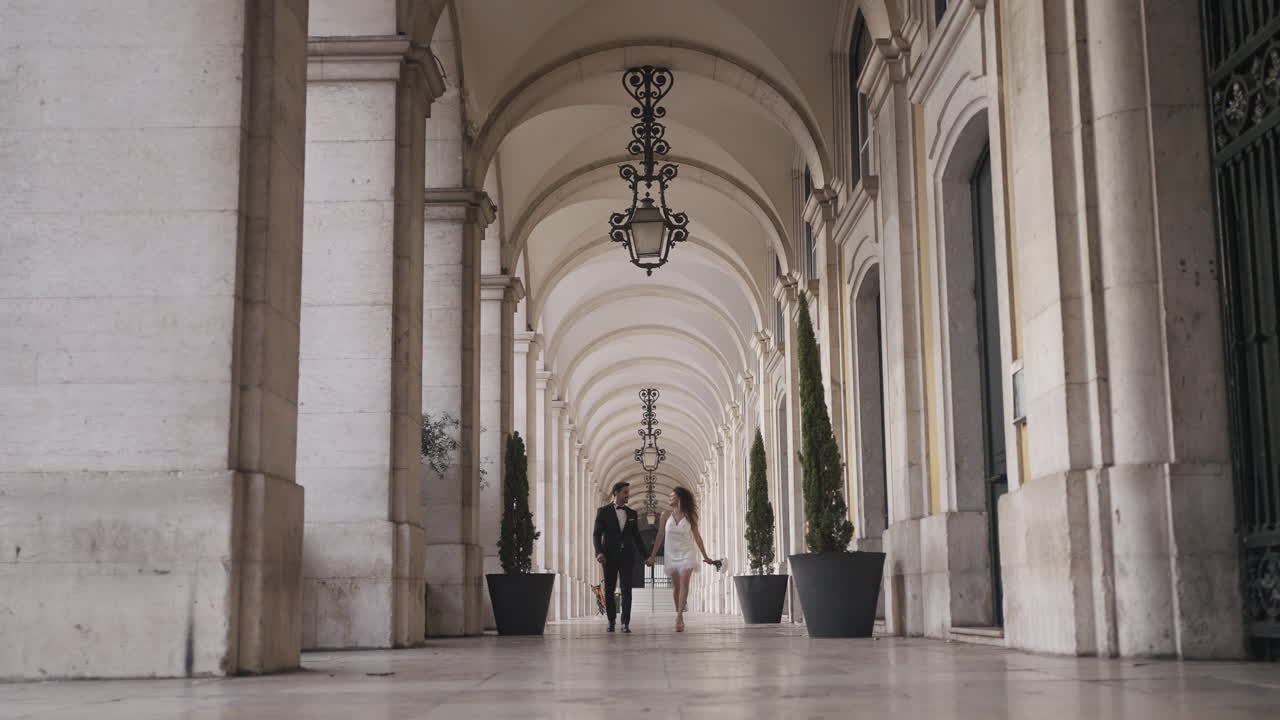 Couple Walking Through an Architectural Archway in Lisbon