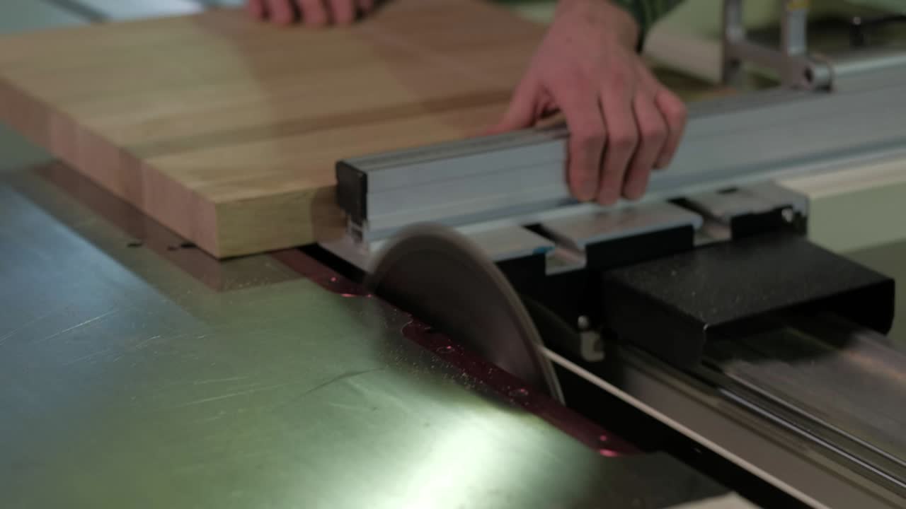 trabajador en camuflaje aserradura de madera en la máquina, aserrado de madera en un telar circular, el trabajo en el taller