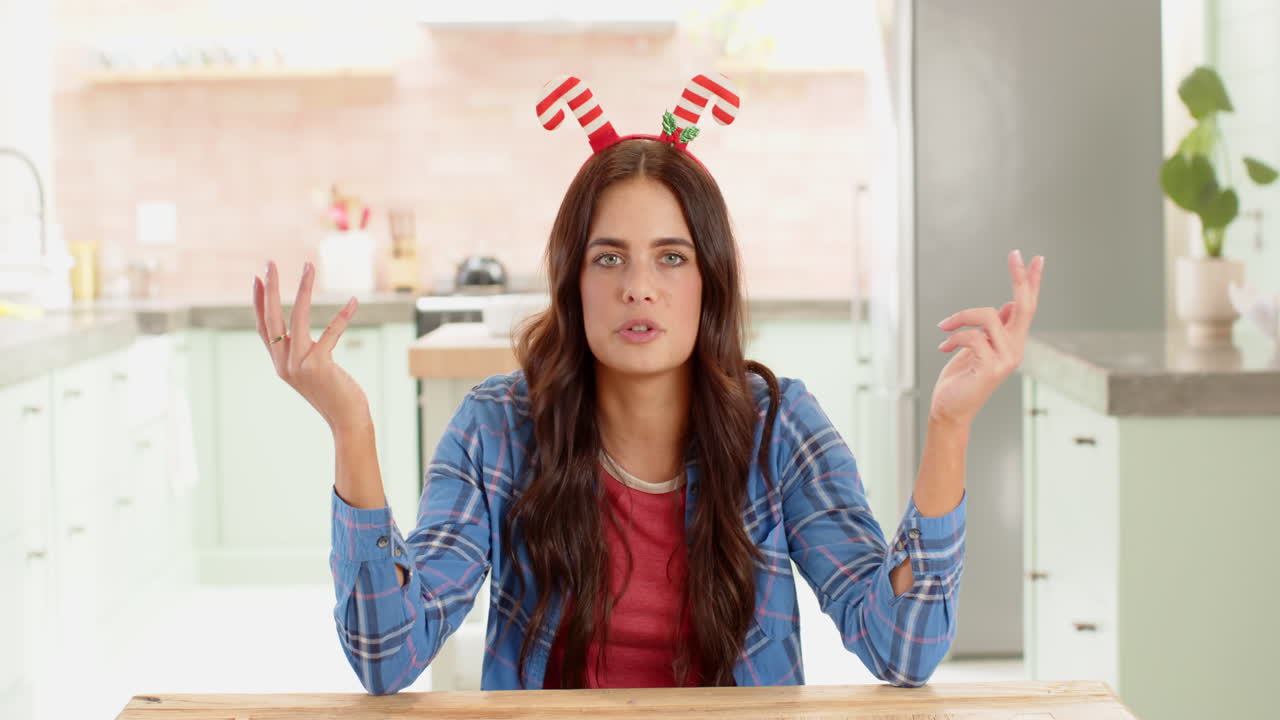 Christmas time, Woman wearing festive headband in kitchen, playfully gesturing and smiling