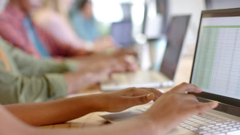 Midsection-of-diverse-business-colleagues-using-phone-headsets-and-laptops-in-office,-slow-motion