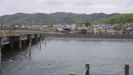 uji river, pan across japan springtime scene with houses in background