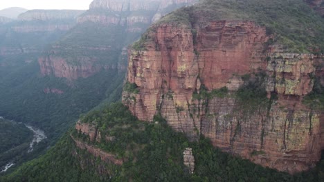 Vista-Aérea-A-Lo-Largo-De-Las-Verdes-Rocas-Cubiertas-De-Vegetación-De-Drakensberg-En-áfrica