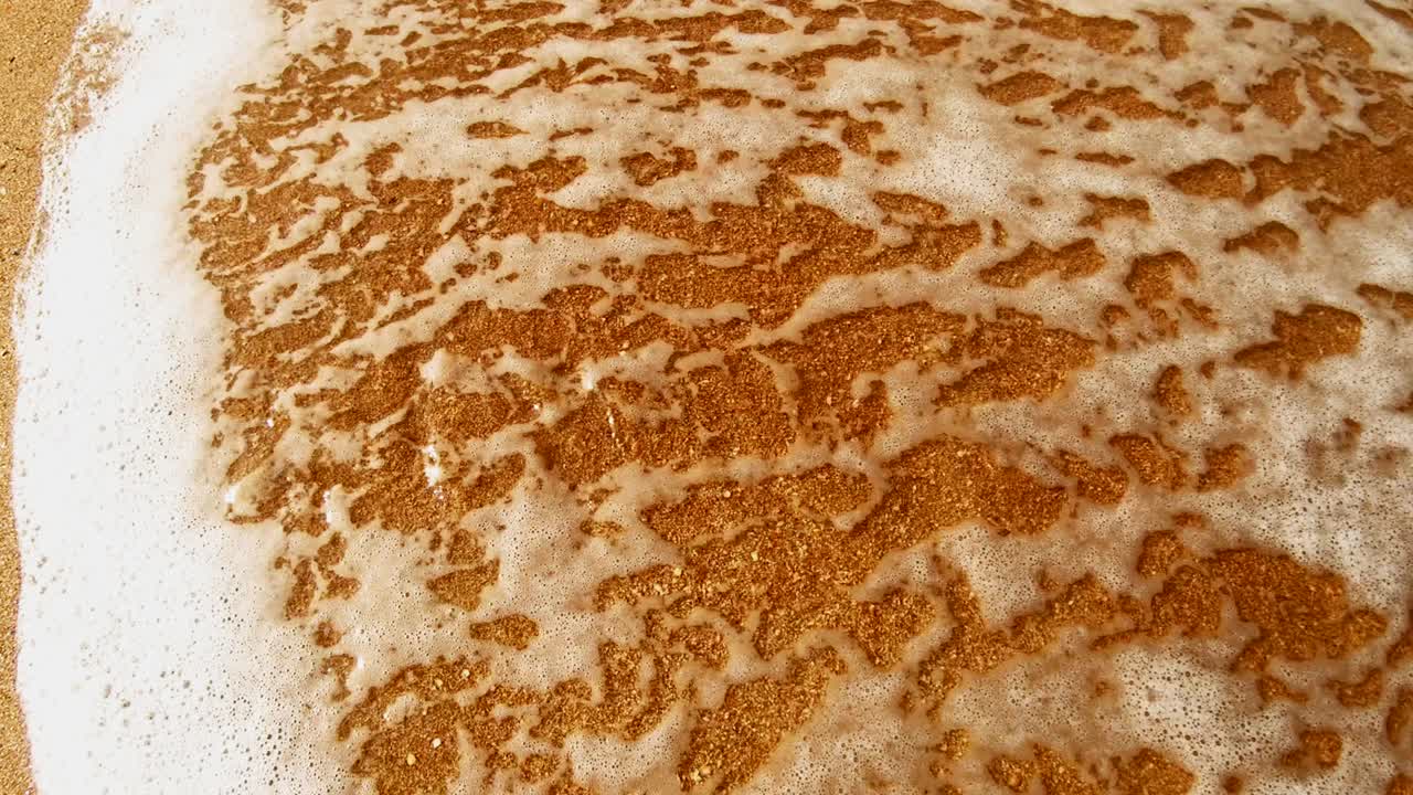 hermosas letras de verano en la arena cálida lava el agua del mar en un día soleado.