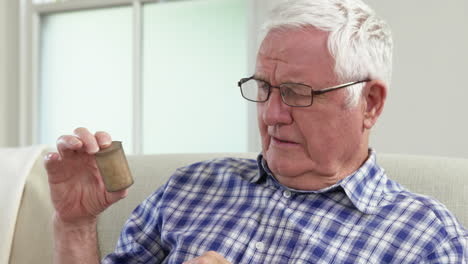 senior man looking at pills