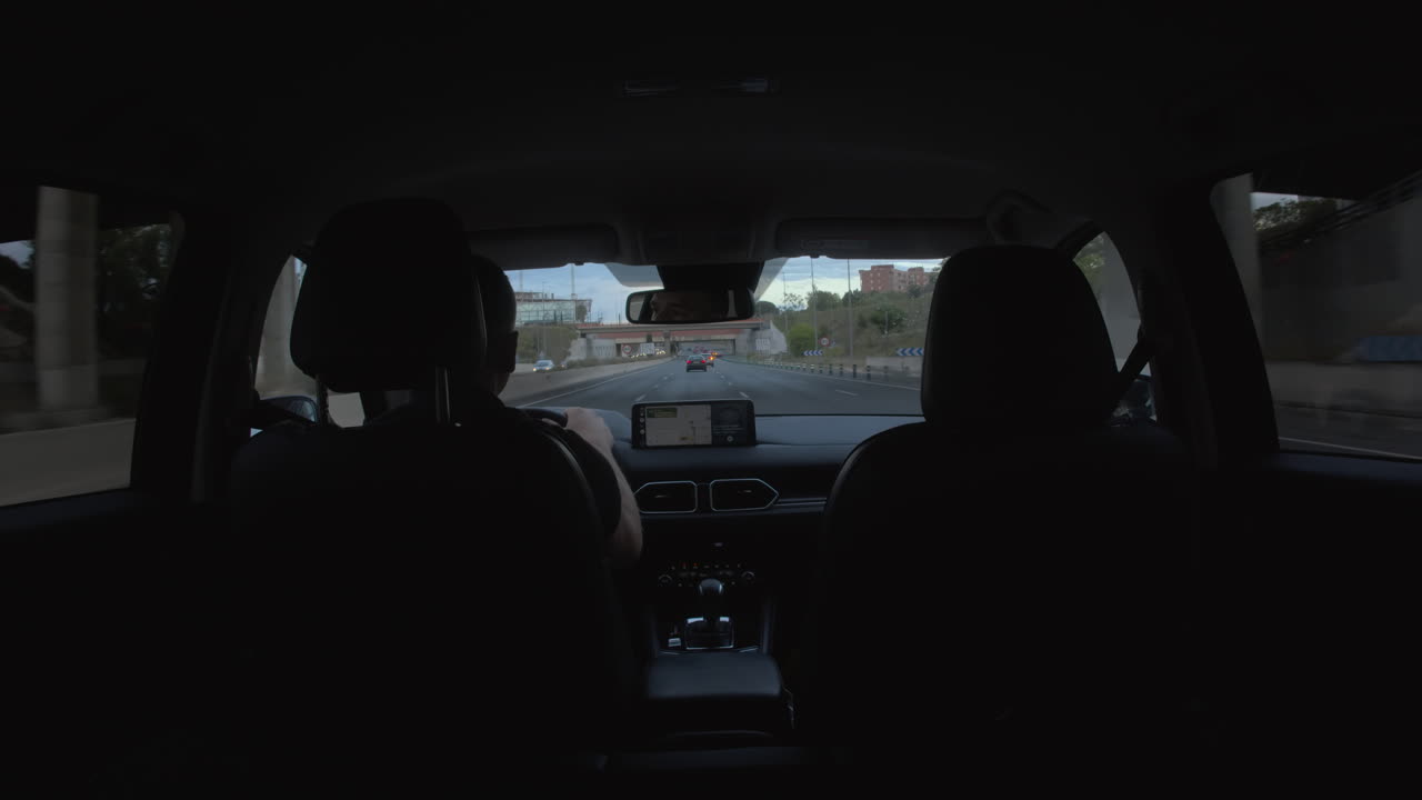 아버지는 아들을 차로 운전하고 있습니다.