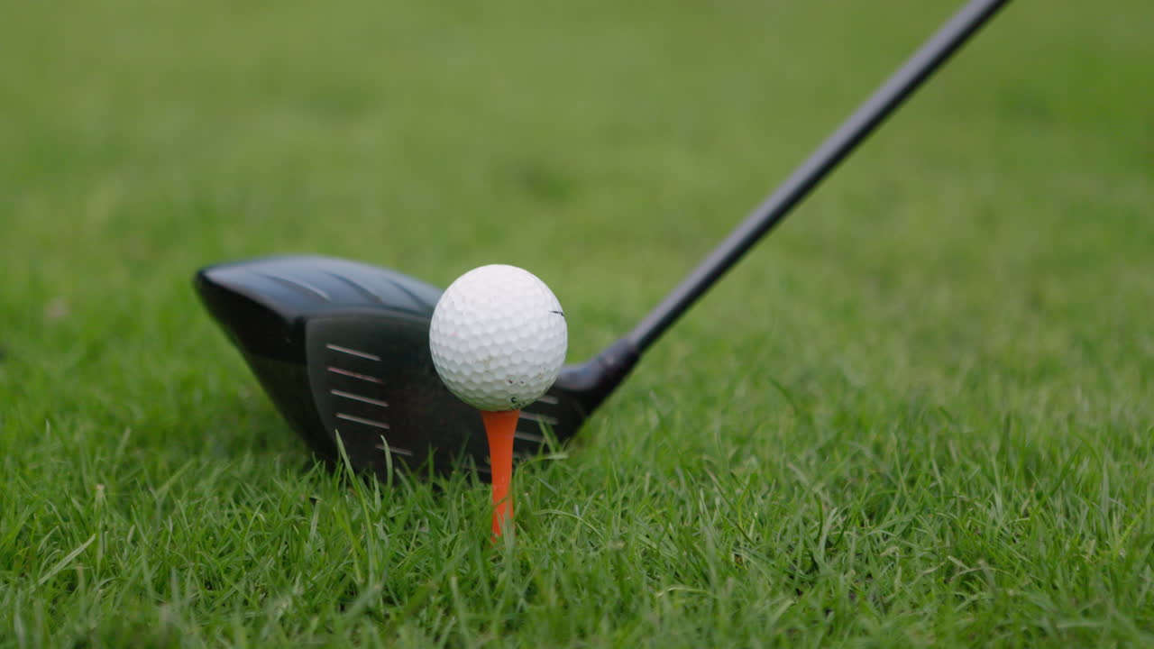 Golf ball on tee with golf club