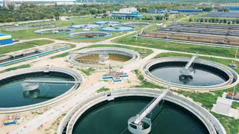 drone shot of round sedimentation tanks at a wastewater treatment plant in daylight. water management concept.