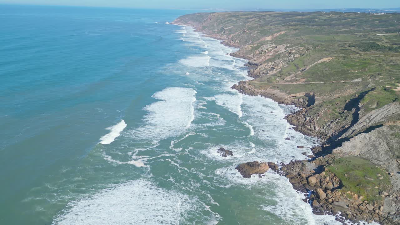 Rocky coastline with waves crashing near Miradouro do Salgado, Nazaré, Portugal