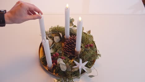 turning off electric candles on christmas advent wreath white background