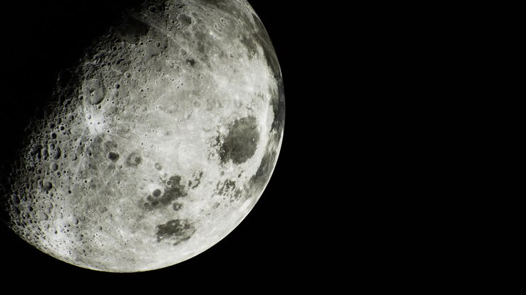 O céu noturno revela uma vista detalhada da superfície da lua e crateras