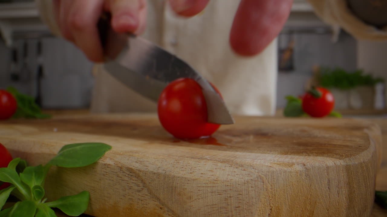 셰프가 토마토를 잘라내고 있습니다.