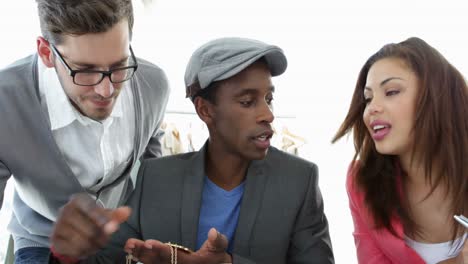 equipo de diseño de moda ocupado trabajando juntos en la mesa mirando joyas