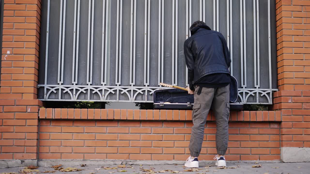 그 남자는 기타를 꺼내서 연주하기 시작합니다.