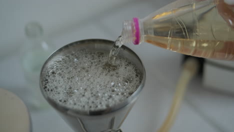 pouring vinegar into a solution in a funnel