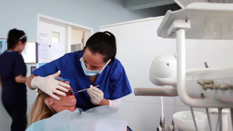 pediatric dentist examining a patients teeth with angled mirror