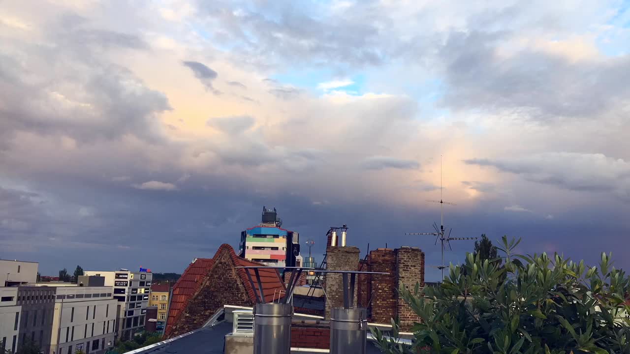 Spectacular 1 hour timelapse from the rain shower over the roofs of Berlin with a beautiful rainbow to the clear, slightly cloudy sky. Old chimneys antennas bird. Cinematic 1080, by Philipp Marnitz