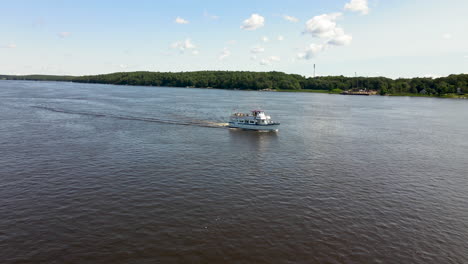 Small-Cruise-Ship-sailing-down-a-calm-river,-lovely-sunny-day