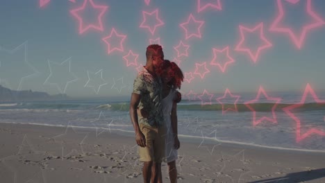 Animation-of-neon-stars-changing-colours-over-happy-african-american-couple-walking-on-beach