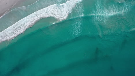 Klare-Wasseroberfläche-über-Dem-Südafrikanischen-Ozean-Mit-Surfer-Luftaufnahmen-Von-Oben