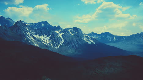 aerial over valley with snow capped mountains in distance