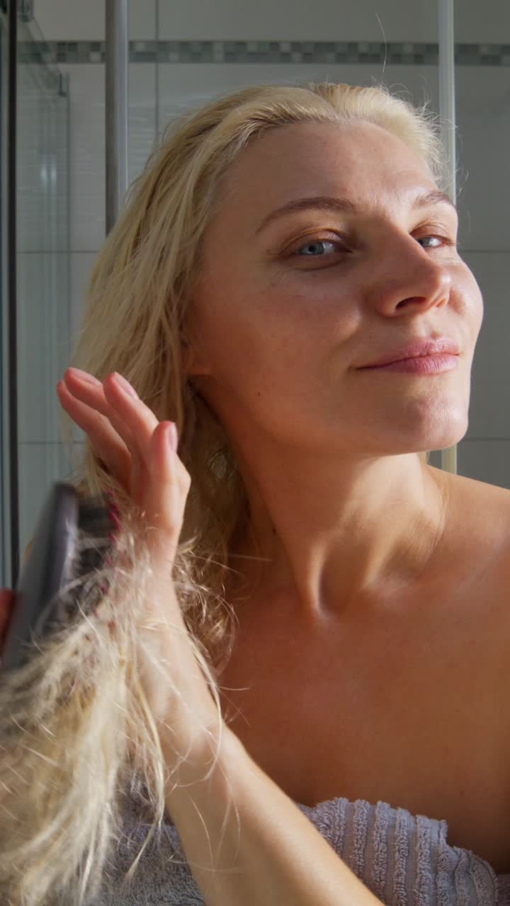 mujer secándose el cabello en el baño