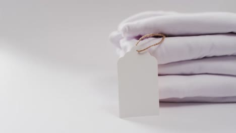 Video-of-stack-of-folded-white-t-shirts-with-copy-space-on-white-background