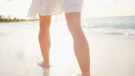 legs of female caucasian barefoot on ocean beach