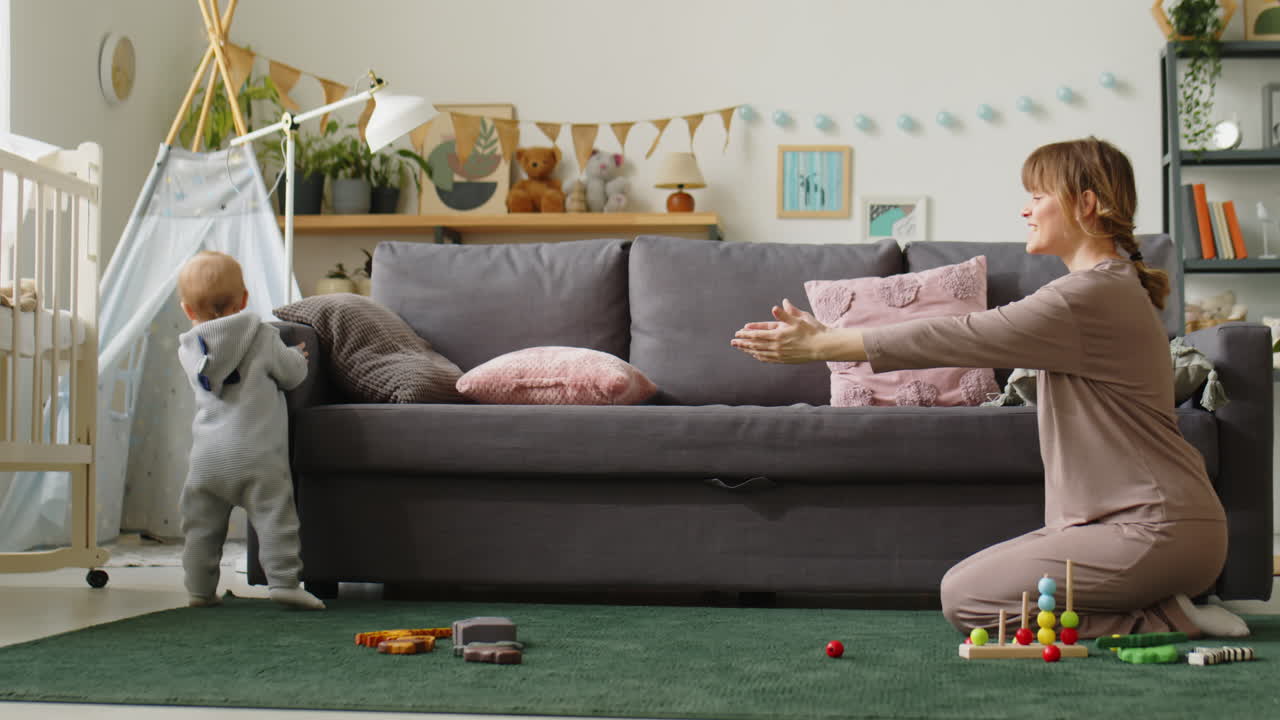 Toddler Boy Making First Steps with Mom at Home