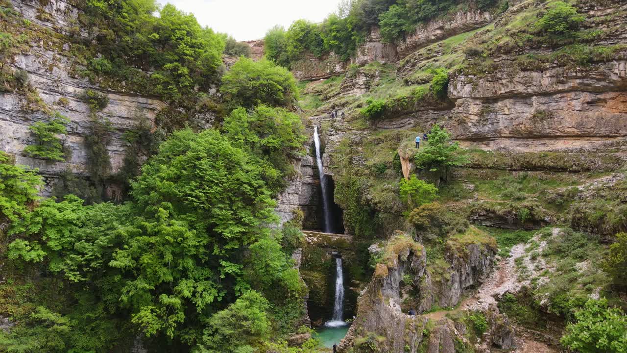 vista aérea de la pintoresca cascada de pestura y el paisaje del cañón en albania, con algunos individuos que se ven escalando