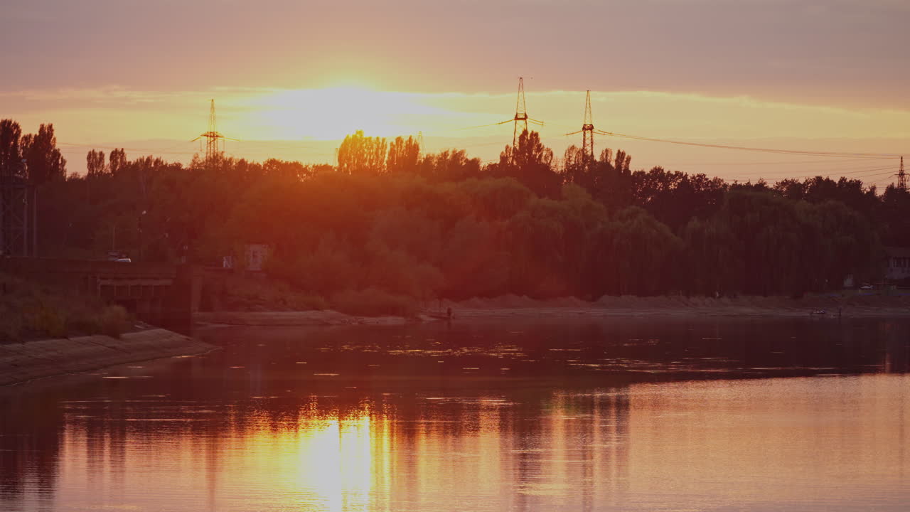 Beautiful sunset above trees and river. Evening sky reflection on water. Countryside scene. Rural landscape.