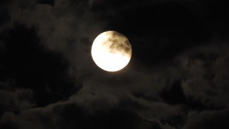 luna por la noche con nubes en tiempo real. 4k video luna en el cielo negro. nubes pasando por la luna por la noite. cielo nocturno con tiempo nublado