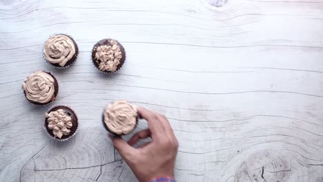 mano alcanzando un pastel de chocolate en una mesa de madera