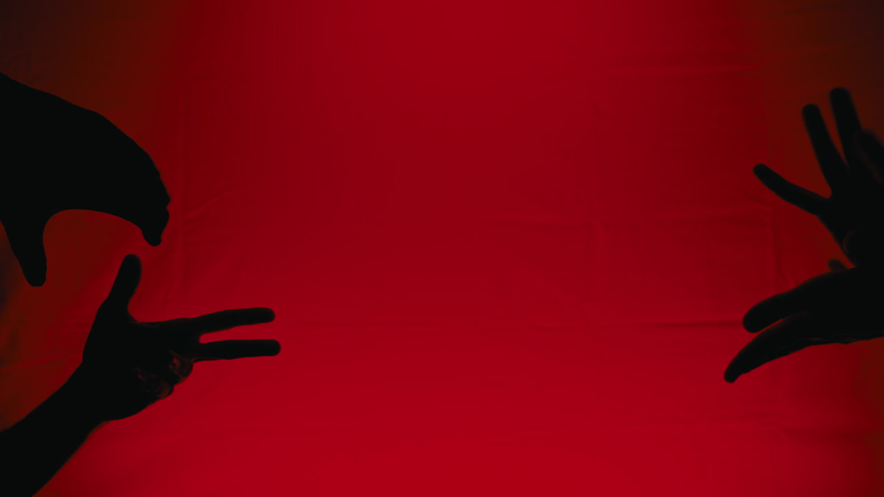 Silhouette of hands on a red background for Halloween horror