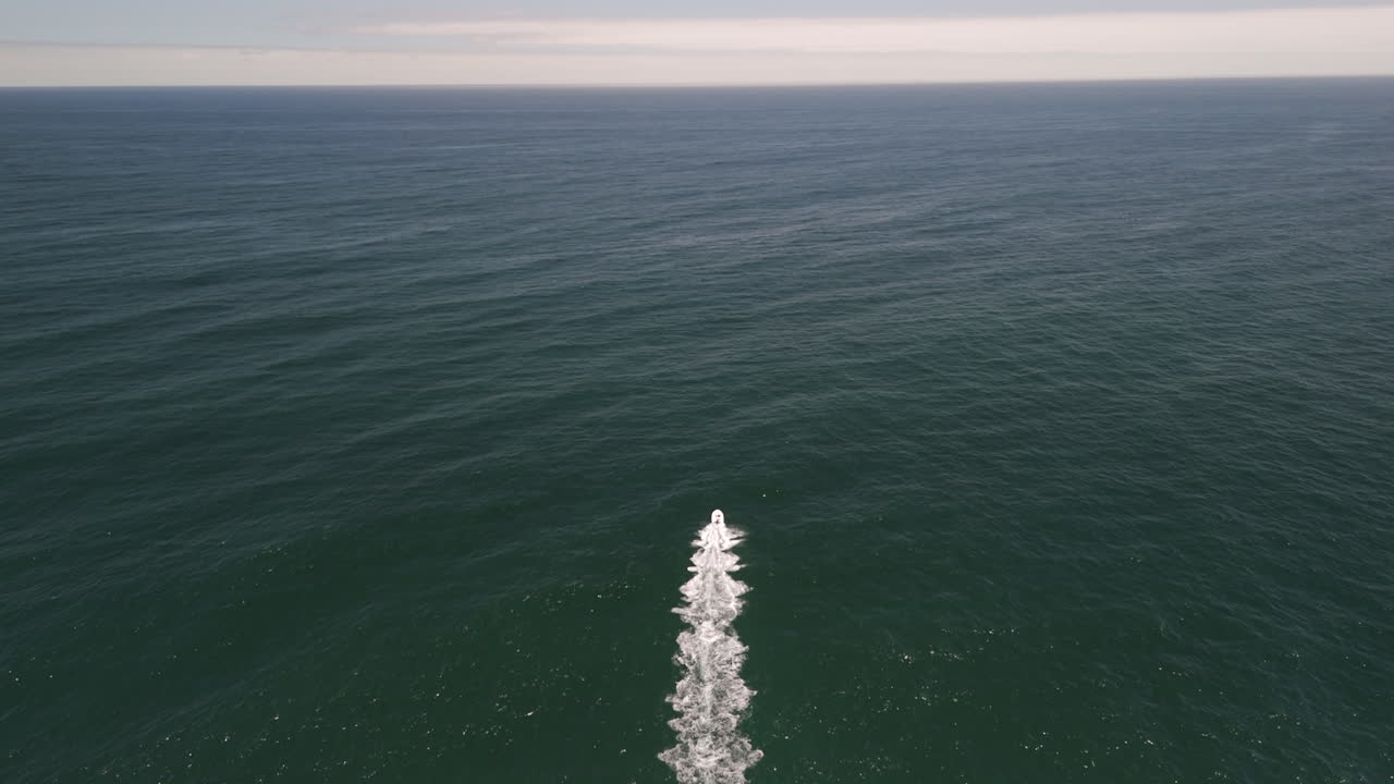 Following shot of Motorboat speed by on the ocean waves