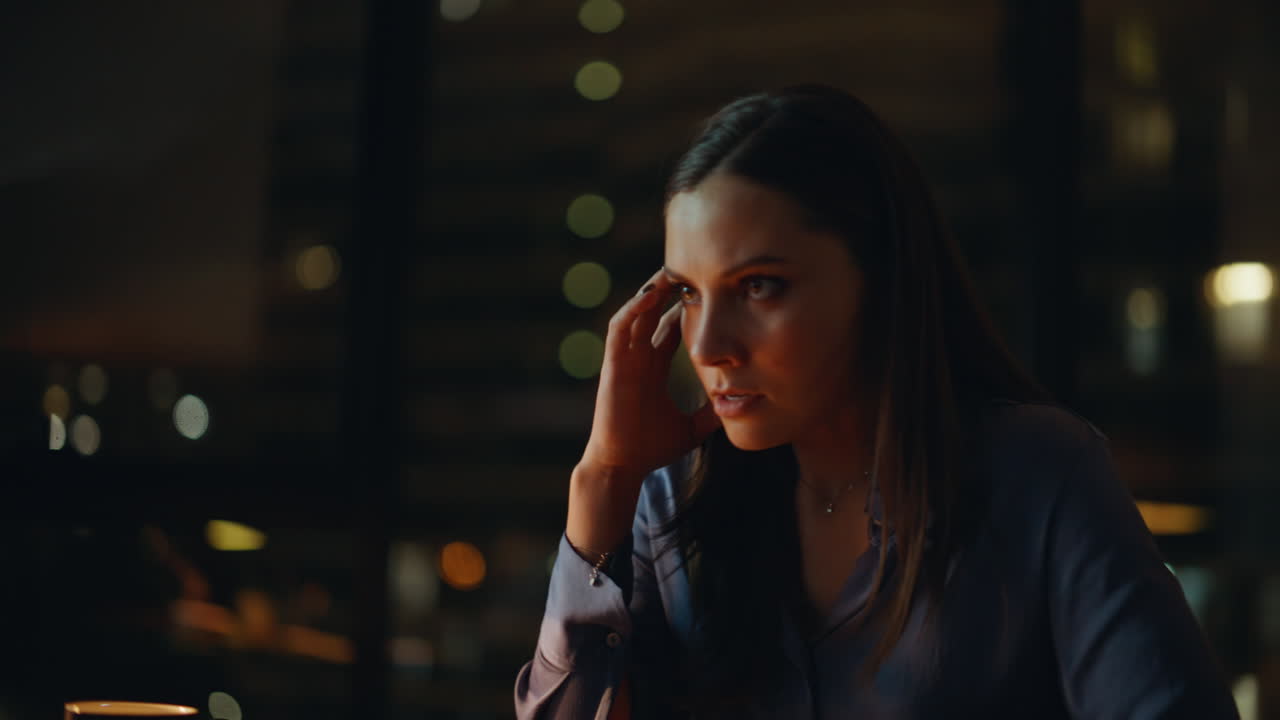 Irritated businesswoman video calling by laptop at night office closeup