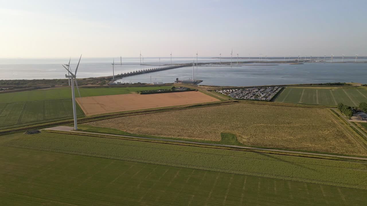 공중 - 일몰 동안 네덜란드의 폭풍 해일 장벽을 따라 흩어져 있는 수많은 풍력 터빈