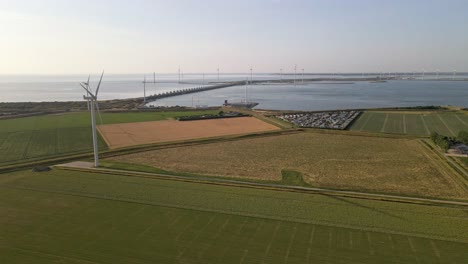 AERIAL---Numerous-wind-turbines-scattered-along-the-storm-surge-barriers-in-the-Netherlands-during-sunset