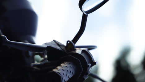 Close-Up-Of-Side-Mirror,-Hand-Brake,-And-Throttle-Of-A-Motorcycle