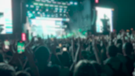 defocused concert audiences of a live band performance at the city in nighttime