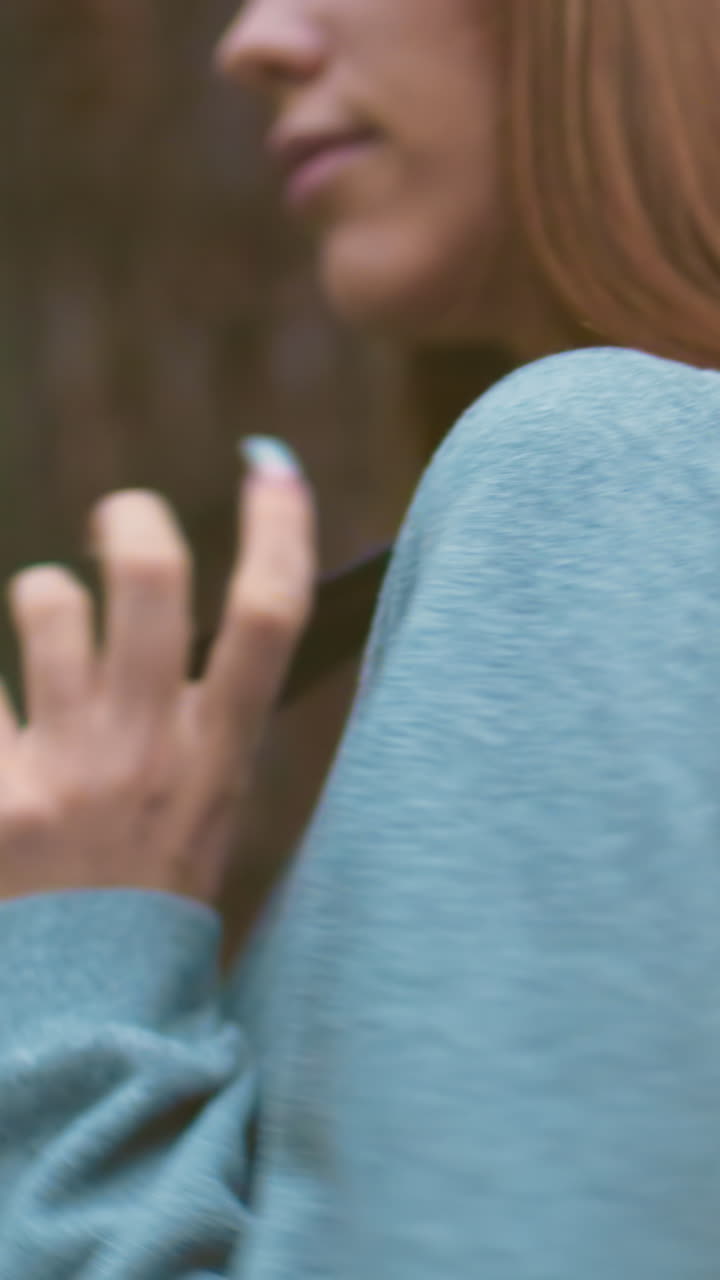 primer plano de un joven excursionista haciendo una pausa en un bosque sereno, colgando una bolsa sobre el hombro con el cabello largo fluyendo y una bandana azul, rodeada de árboles altos y vegetación exuberante, sostiene la bolsa con gracia