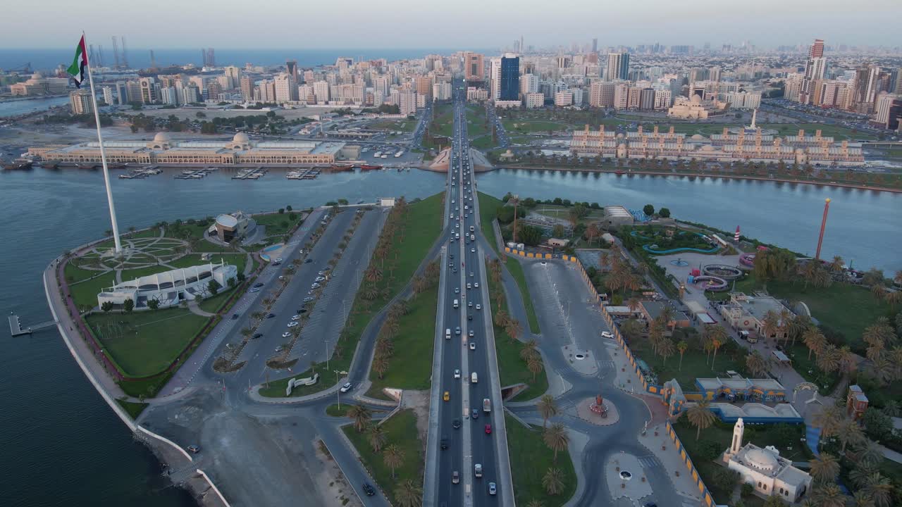 sharjah desde arriba, vista aérea de la ciudad de sharjah y el lago khalid, isla de la bandera en una hermosa tarde, movimiento de tráfico urbano en el puente, negocios de turismo de viajes en los emiratos árabes unidos