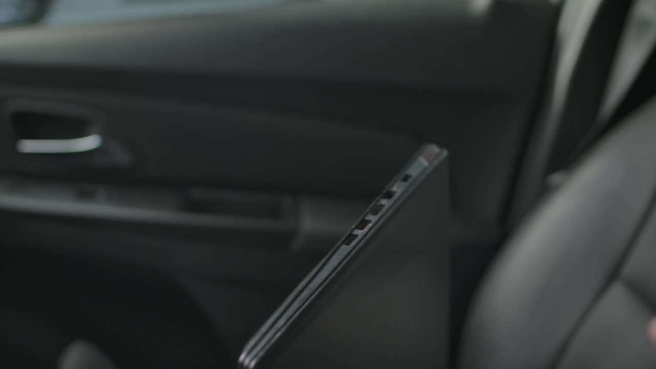 conectando a mano el adaptador de red inalámbrica en el puerto usb de la computadora portátil contra el fondo del interior del automóvil