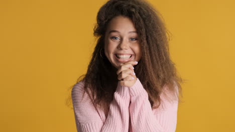 excited caucasian curly haired woman smiling to the camera.