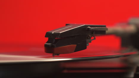 slider move on a red retro record players needle dropping on to a vintage vinyl music album, left to right