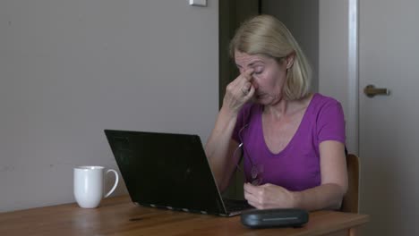 Mujer-Con-Gafas-Se-Frota-Los-Ojos-Cansados,-Con-Exceso-De-Trabajo-En-La-Computadora-Portátil