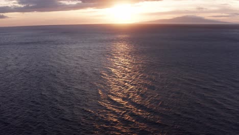 Low-tilting-up-aerial-shot-of-the-private-island-of-Lanai-during-sunset-from-Wailea-in-South-Maui,-Hawai'i