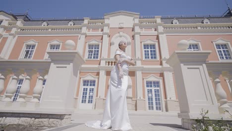 elegant bride in a white dress in front of a palace